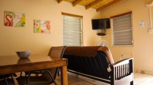 a dining room with a table and a crib and a television at Cozy 2BR Cabin with Pool in Cabo Rojo in Cabo Rojo