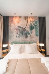 a bedroom with a large bed with a painting on the wall at Noah Gate Hotel & Suites in Naples