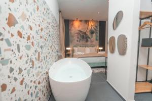 a bathroom with a white tub in a room at Noah Gate Hotel & Suites in Naples +261 photos