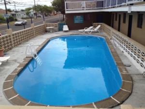 a large blue swimming pool in front of a building at Atlantic Inn Seaside Heights in Seaside Heights