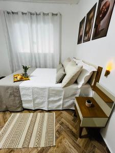 a bedroom with a large bed and a table at Casa centro de Peruíbe in Peruíbe