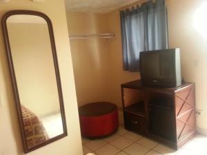 a mirror and a television on a dresser with a tv at Atlantic Inn Seaside Heights in Seaside Heights