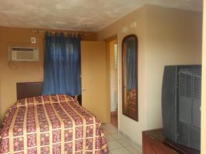 a bedroom with a bed and a tv in it at Atlantic Inn Seaside Heights in Seaside Heights
