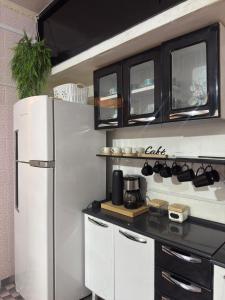 a kitchen with a refrigerator and a counter top at Sobrado versátil in Santo André
