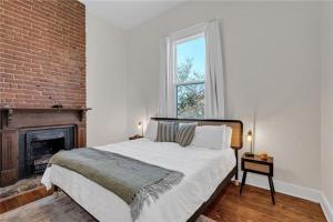 a bedroom with a large bed and a fireplace at Prytania Pearl - 3 Bedroom 2 Bathroom Home in New Orleans