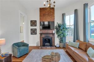 a living room with a couch and a fireplace at Prytania Pearl - 3 Bedroom 2 Bathroom Home in New Orleans
