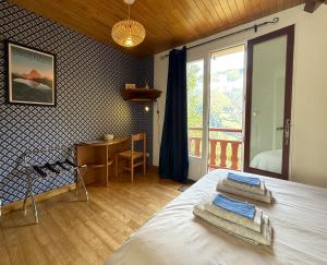 a bedroom with a bed and a desk and a window at L'espiatet in Borce