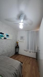 a bedroom with a ceiling fan and a bed at Quarto da Orla in Cabo Frio +9 photos