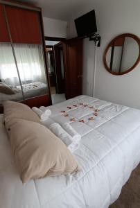 a large white bed with roses on it in a bedroom at Tu piso en el Camino de Santiago in Sarria