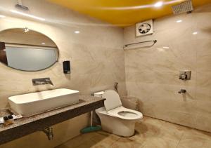a bathroom with a sink and a toilet and a mirror at Tapovan Namaste in Rishīkesh