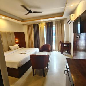a hotel room with a bed and a desk at Tapovan Namaste in Rishīkesh