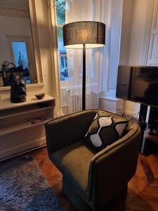 a living room with a couch and a lamp at App T2 avec piscine chauffée in Luchon