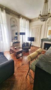 a living room with a couch and chairs and a fireplace at App T2 avec piscine chauffée in Luchon