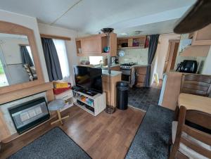 a living room with a tv and a kitchen in a caravan at Casa di Palli in Mariënberg