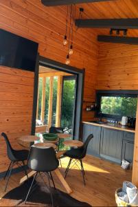 a kitchen and dining room with tables and chairs at Paul Lake Escape Residence in Novosëlki