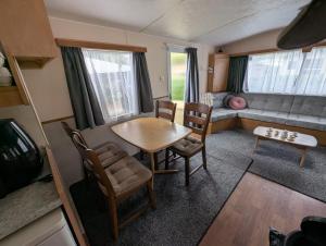 a living room with a table and chairs and a couch at Casa di Palli in Mariënberg +15 photos