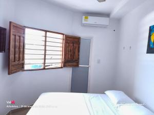 a bedroom with a bed and a window at GTH Hostal in Arboletes