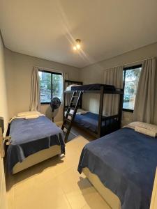 a bedroom with two beds and a bunk bed at Social Hostel Café e Bar in Curitiba