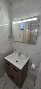 a bathroom with a sink and a mirror at Por do Sol in Caniço