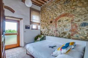 sypialnia z łóżkiem i kamienną ścianą w obiekcie Country House Art and Garden w mieście Monte Antico +37 zdjęć