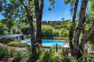 a swimming pool in a garden with trees at La Sérénité in Najac