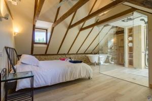 a bedroom with a bed and a bathroom with a tub at La Sérénité in Najac