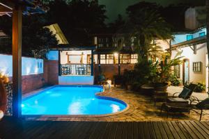 a swimming pool in a backyard at night at Casa Aldeia Paraty in Paraty +53 photos