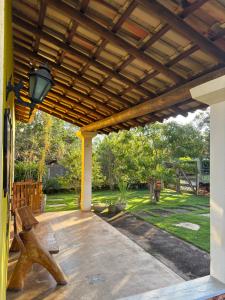 a patio with a wooden pergola and a bench at Espaço Amarelo in Pirenópolis +83 photos