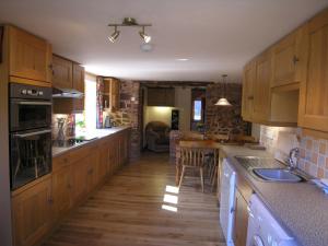 a kitchen with wooden cabinets and a counter top at Stables- Ukc4912 in Timberscombe