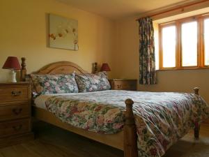 a bedroom with a bed and two windows at Stables- Ukc4912 in Timberscombe