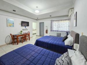 a hotel room with two beds and a table at Casa San Luis in Tuxtla Gutiérrez