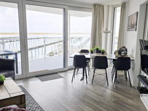 a living room with a table and chairs and a balcony at Exklusive Meerblickwohnung in 1 Reihe in Wendtorf +14 photos