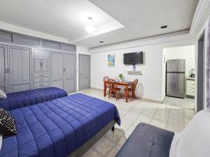 a bedroom with a bed and a table with a kitchen at Casa San Luis in Tuxtla Gutiérrez