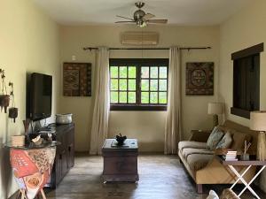 a living room with a couch and a tv at Espaço Amarelo in Pirenópolis