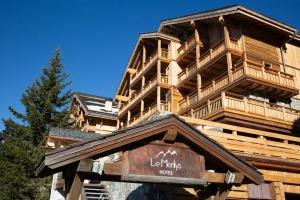 a large wooden building with a sign in front of it at Hotel & Spa Merilys in Méribel