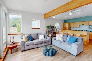 a living room with two couches and a kitchen at Lake Sutherland Retreat in Port Angeles