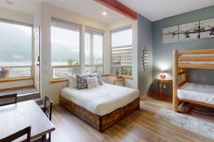 a bedroom with a bed and a table and some windows at Lake Sutherland Retreat in Port Angeles