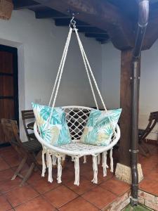 a hanging porch swing with pillows on it at La villa de Leo y Lola in Frómista