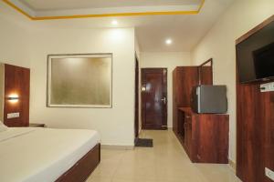 a bedroom with a bed and a flat screen tv at Tapovan Namaste in Rishīkesh +29 photos