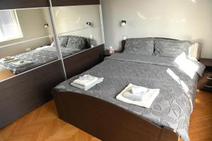 a bedroom with two beds with mirrors and towels at Mustache 3 Room Apt City Center in Bitola