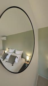 a mirror reflecting a bed in a room at Chambre d'hôtes - B&B - Le Cocon de Manon en Luberon in Lagnes