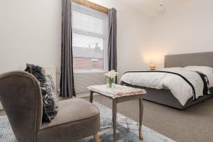 a bedroom with a bed and a chair and a table at Modern 3-Bedroom Home in-Steps from Crown Point in Denton