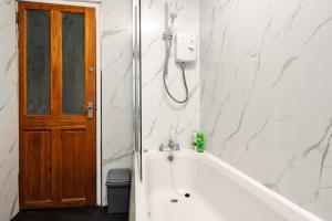 a bath tub in a bathroom with a wooden door at Modern 3-Bedroom Home in-Steps from Crown Point in Denton +43 photos