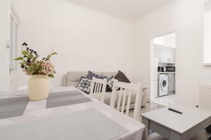 a white living room with a table and a couch at Modern 3-Bedroom Home in-Steps from Crown Point in Denton