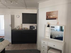 a bedroom with a bed and a kitchen with a microwave at Royal Oak Rooms in Exeter