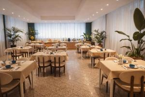 a restaurant with tables and chairs in a room at Hotel Pex Verona in Verona