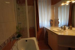 a bathroom with a bath tub and a sink at Júlia Apartman in Balatonalmádi +32 photos
