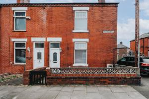 a red brick building with a white door at Modern 3-Bedroom Home in-Steps from Crown Point in Denton