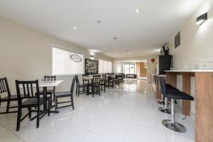 a restaurant with black chairs and a white floor at Super 8 by Wyndham Golden in Golden
