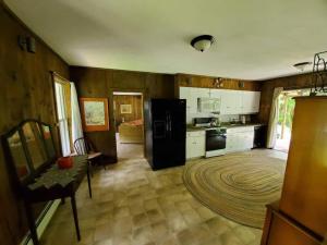a kitchen with white cabinets and a black refrigerator at Vermont Escape, Too in Warren